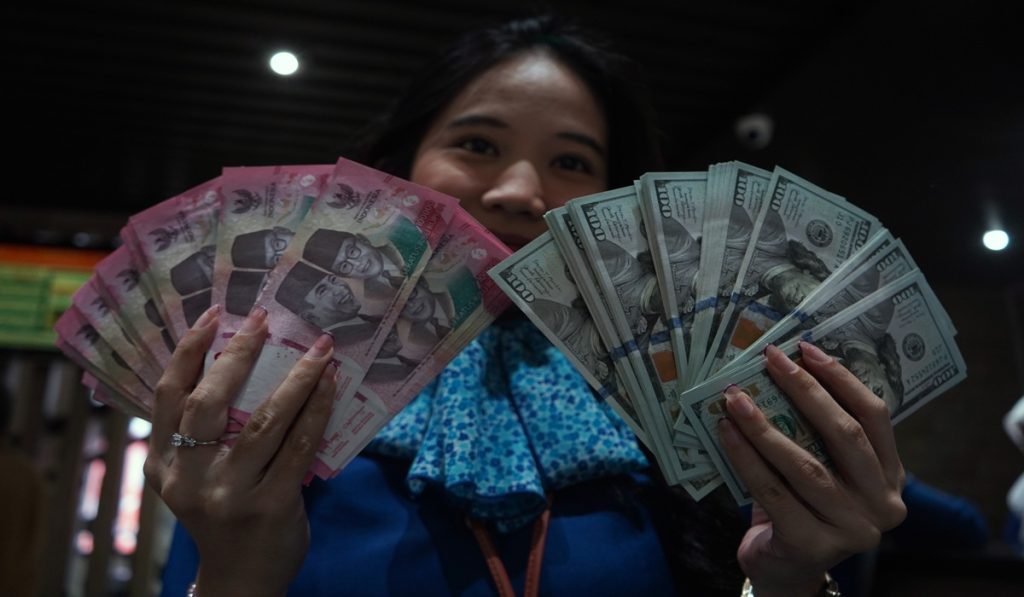 Karyawan menunjukkan uang pecahan rupiah dan dolar Amerika Serikat (AS) di gerai penukaran mata uang asing Haji La Tunrung, Makassar, Sulawesi Selatan, Rabu (20/5/2026).