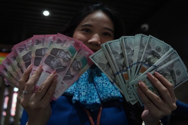 Karyawan menunjukkan uang pecahan rupiah dan dolar Amerika Serikat (AS) di gerai penukaran mata uang asing Haji La Tunrung, Makassar, Sulawesi Selatan, Rabu (20/5/2026).