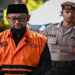 Tersangka kasus dugaan korupsi kuota haji Ishfah Abidal Aziz atau Gus Alex (kiri) berjalan menuju ruang pemeriksaan di Gedung Merah Putih KPK, Jakarta, Jumat (12/6/2026).