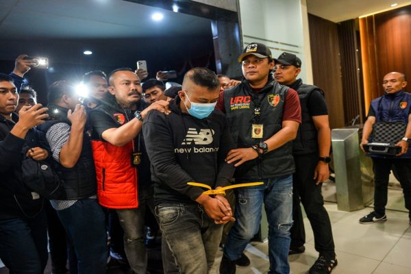 Petugas menggiring tersangka kasus dugaan penyekapan dan penganiayaan berat Taufik Hidayat (tengah) setibanya di Polda Jabar, Bandung, Jawa Barat, Selasa (23/6/2026).